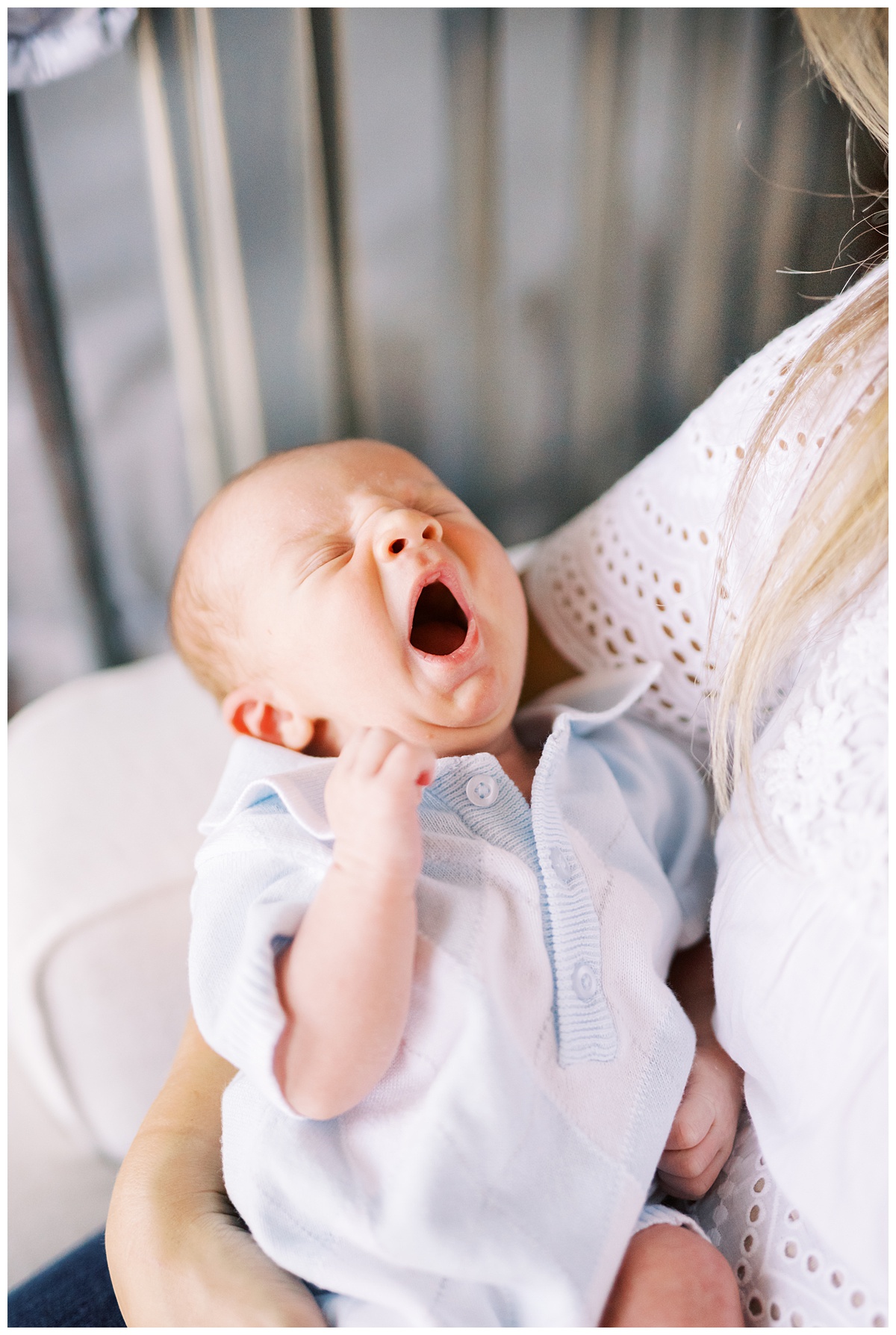 yawning newborn in its mother's arms